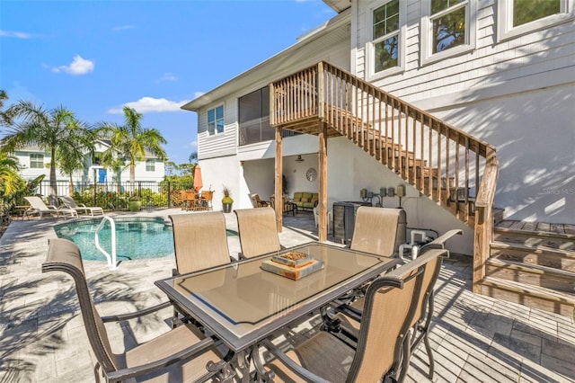 view of patio / terrace with a fenced in pool, outdoor dining area, fence, and stairs