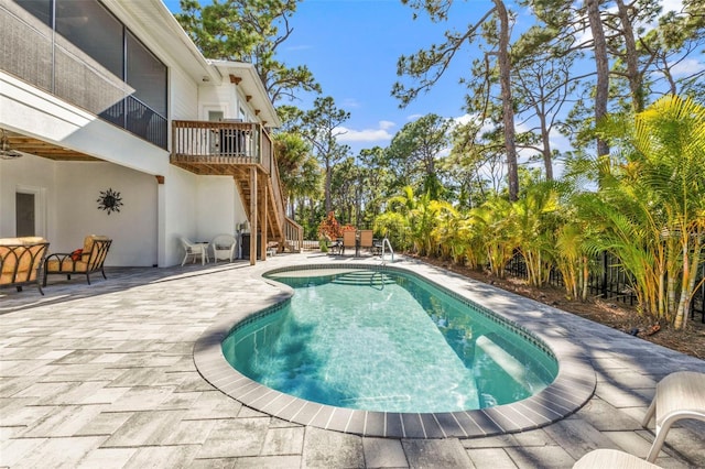 pool with a patio area and stairway