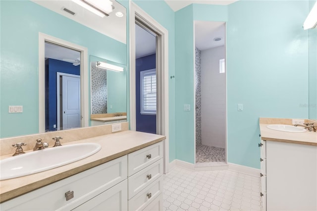 bathroom with tiled shower and vanity