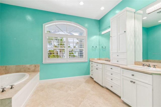 bathroom featuring vanity and tiled tub