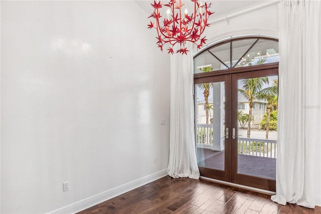 entryway with french doors, an inviting chandelier, and dark wood-type flooring