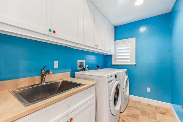 laundry room with sink, washing machine and dryer, and cabinets