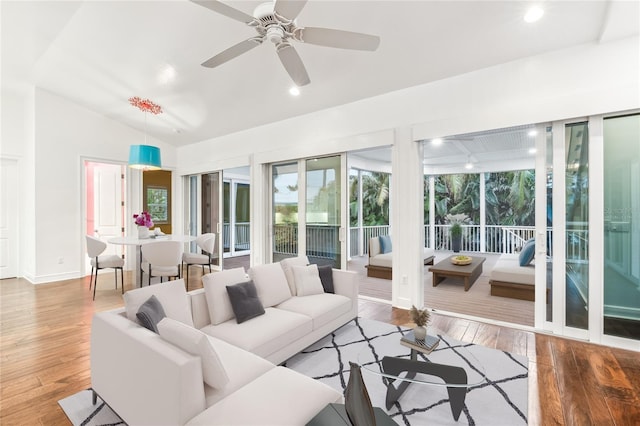 living room with lofted ceiling, hardwood / wood-style floors, and ceiling fan