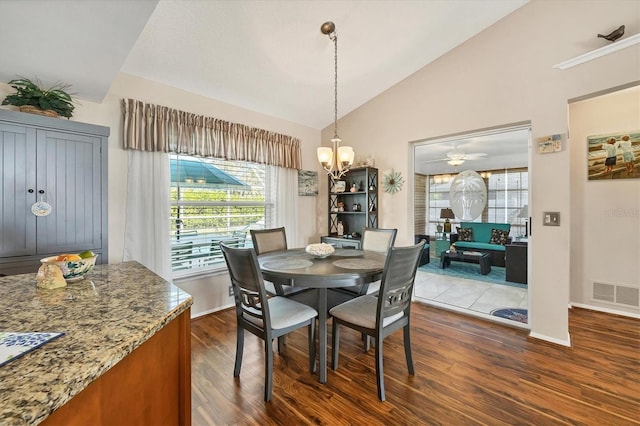 dining room with lofted ceiling, a notable chandelier, and dark wood-type flooring