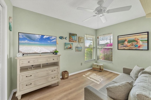 living room with ceiling fan and light hardwood / wood-style flooring