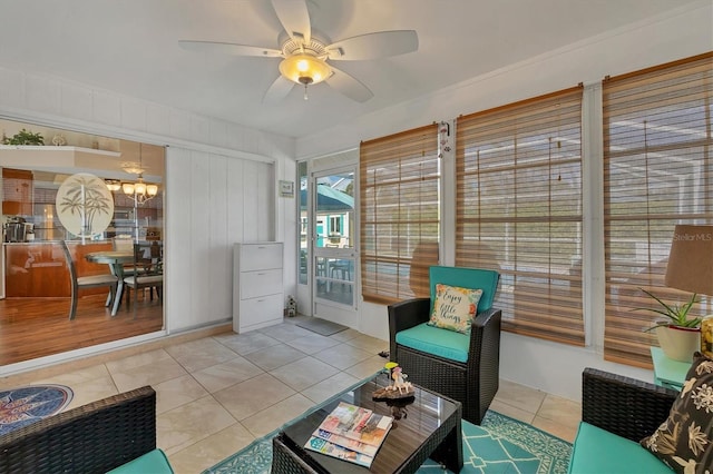 interior space with ceiling fan, wooden walls, and light tile patterned floors