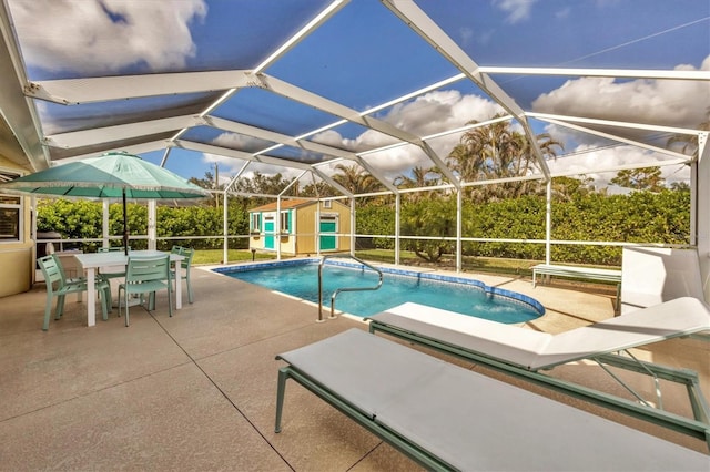 view of swimming pool featuring a storage shed, a lanai, and a patio