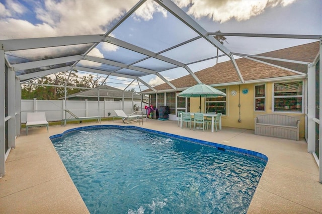 view of pool with glass enclosure and a patio