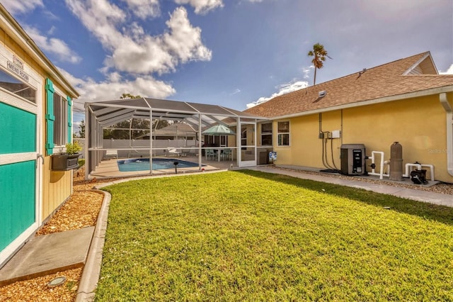 rear view of house with a fenced in pool, a patio area, a lawn, and glass enclosure