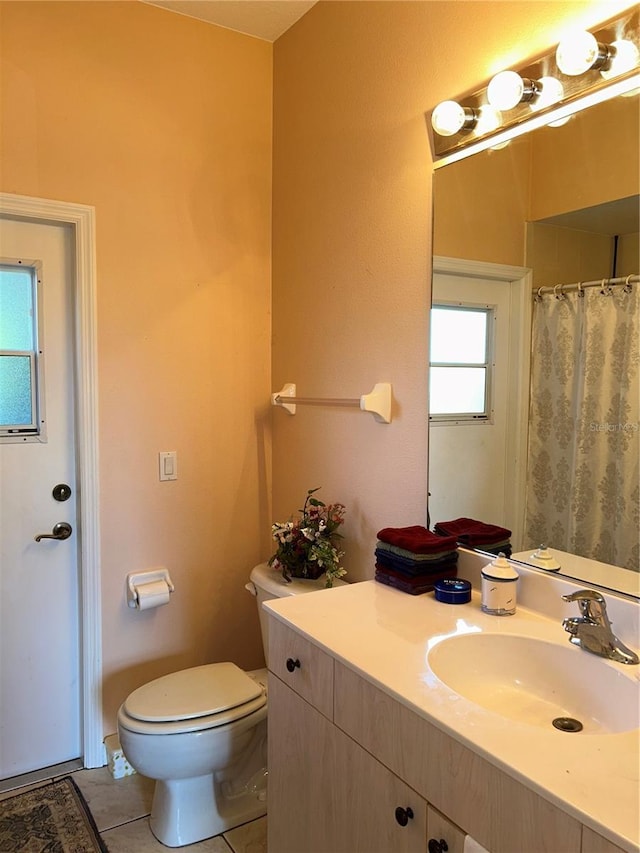 bathroom with tile patterned flooring, vanity, and toilet