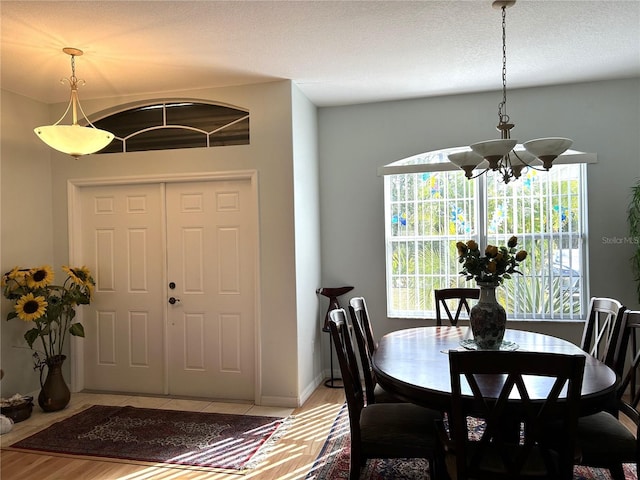 dining area with light wood-type flooring and an inviting chandelier