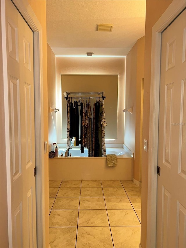 bathroom featuring a textured ceiling and tile patterned floors