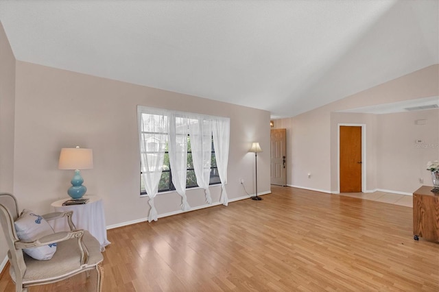 living room featuring light hardwood / wood-style flooring and vaulted ceiling