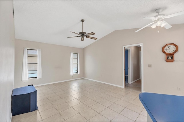 tiled empty room featuring a textured ceiling, ceiling fan, and lofted ceiling