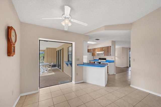 kitchen with ceiling fan, range with electric stovetop, light tile patterned flooring, and a textured ceiling