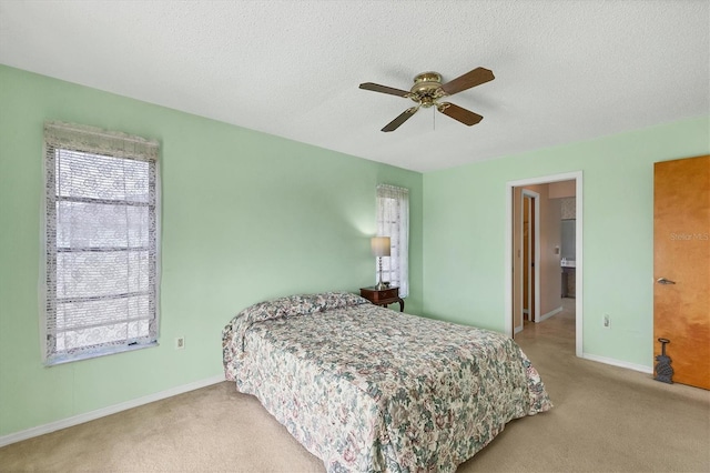 carpeted bedroom featuring ceiling fan and a textured ceiling