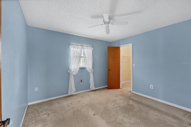 spare room with light carpet, a textured ceiling, and ceiling fan