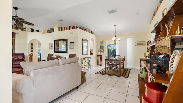 tiled living room featuring ceiling fan with notable chandelier and vaulted ceiling