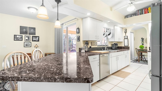 kitchen with stainless steel appliances, white cabinetry, hanging light fixtures, and sink