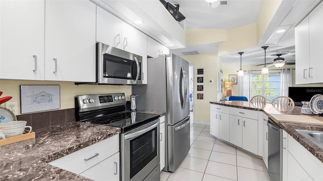 kitchen with ceiling fan, light tile patterned flooring, vaulted ceiling, white cabinets, and appliances with stainless steel finishes