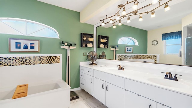 bathroom featuring tile patterned floors, a washtub, vanity, and a healthy amount of sunlight