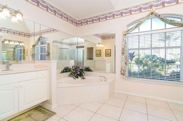 bathroom featuring tile patterned flooring, vanity, and a tub to relax in