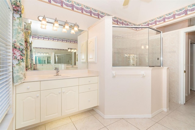 bathroom featuring tiled shower, vanity, tile patterned floors, and ceiling fan