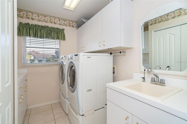 washroom with washer and clothes dryer, sink, light tile patterned flooring, and cabinets