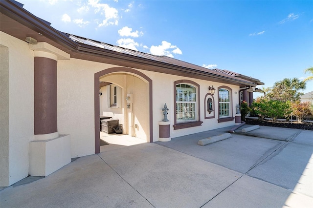 view of exterior entry with a patio