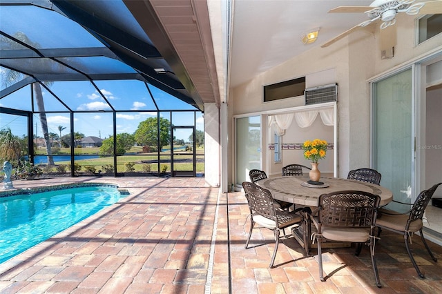 view of pool with glass enclosure, ceiling fan, a water view, and a patio