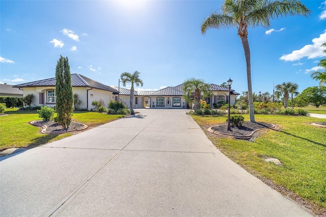 646 Boundary Blvd, Rotonda West, FL 33947 - ranch-style home with driveway, stucco siding, a front yard, metal roof, and a standing seam roof