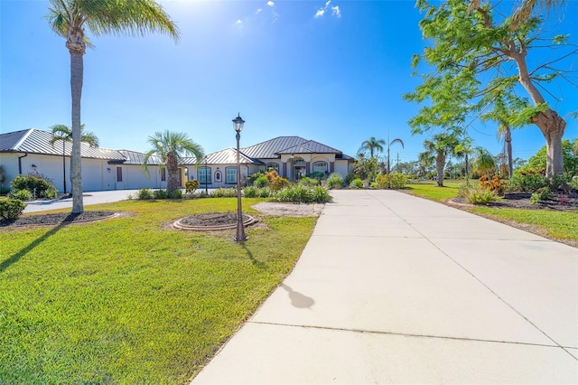 646 Boundary Blvd, Rotonda West, FL 33947 - view of front of property featuring metal roof, a front yard, stucco siding, and driveway