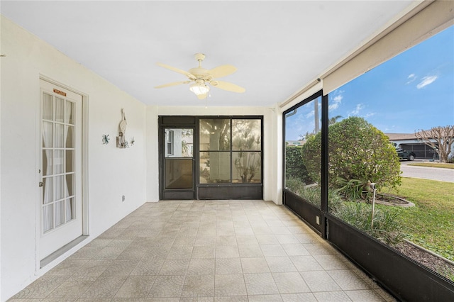 unfurnished sunroom with ceiling fan