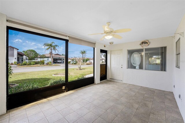 unfurnished sunroom with ceiling fan