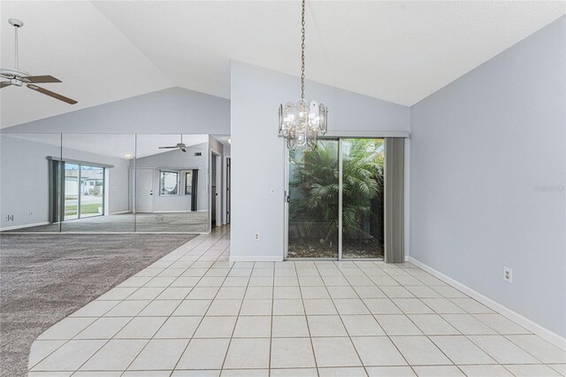 tiled empty room featuring ceiling fan with notable chandelier and vaulted ceiling