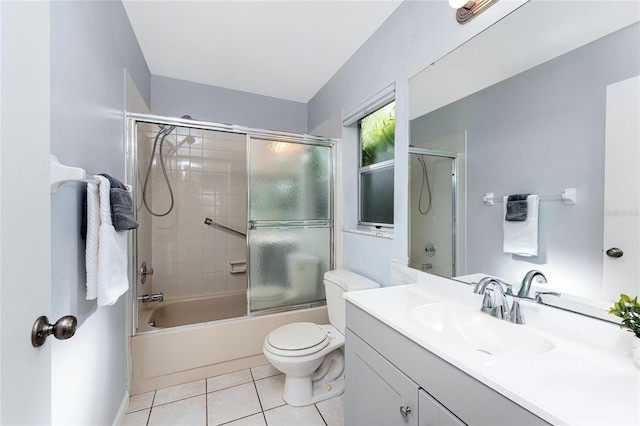 full bathroom with tile patterned flooring, vanity, enclosed tub / shower combo, and toilet