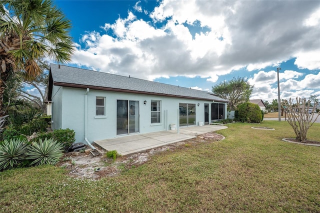 back of property with a yard and a patio area