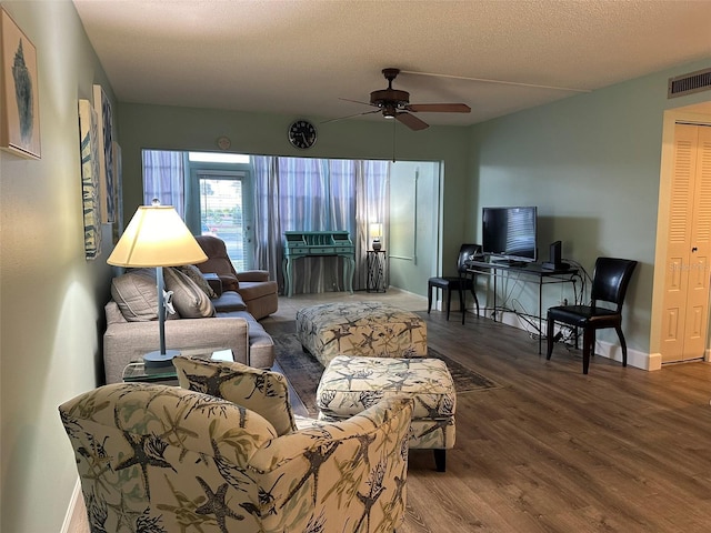 living room with ceiling fan, wood-type flooring, and a textured ceiling