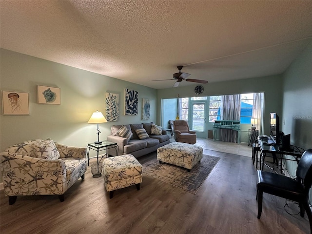 living room with ceiling fan, wood-type flooring, and a textured ceiling