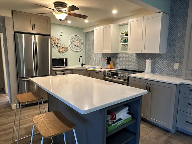 kitchen with a center island, dark hardwood / wood-style flooring, a breakfast bar area, and appliances with stainless steel finishes