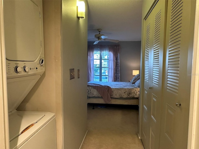 interior space featuring ceiling fan, stacked washing maching and dryer, and a closet