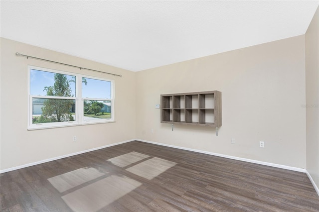 unfurnished room featuring dark wood-type flooring