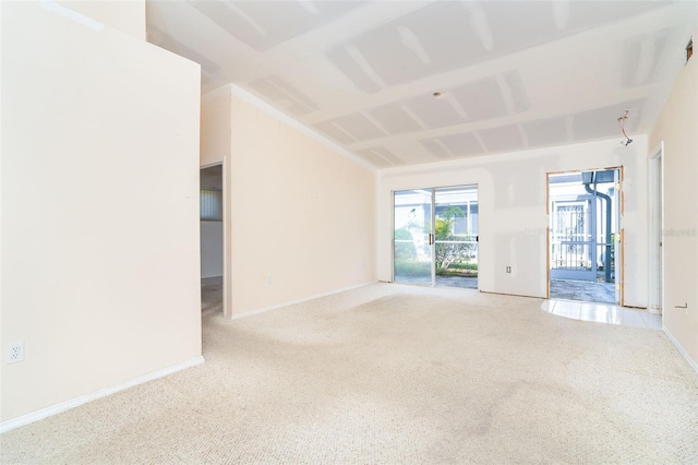 carpeted empty room featuring vaulted ceiling