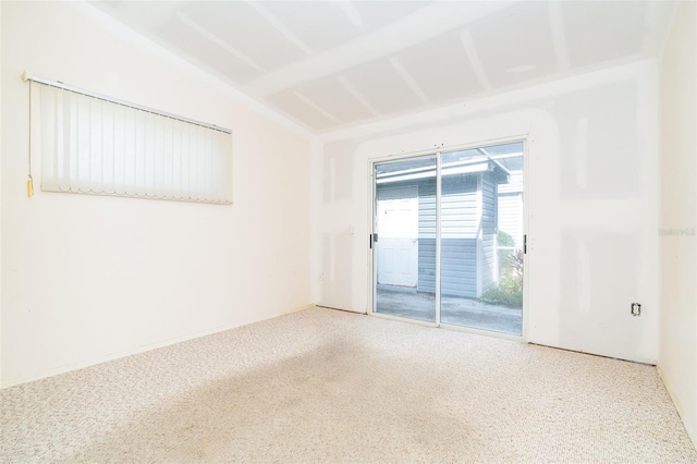 unfurnished room featuring carpet floors and vaulted ceiling