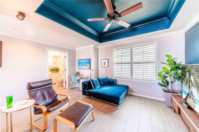 living area with a tray ceiling, ceiling fan, and hardwood / wood-style flooring