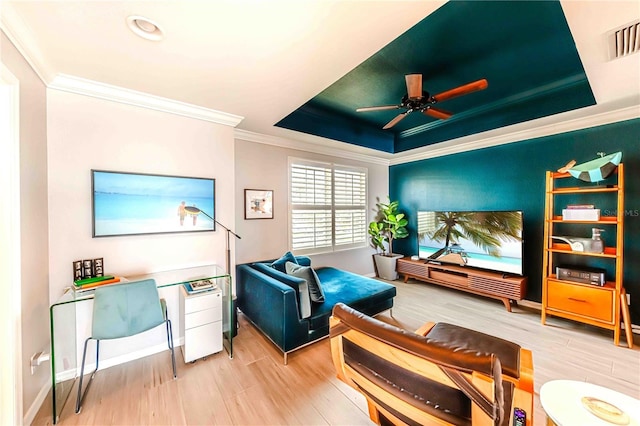 sitting room featuring hardwood / wood-style floors, a raised ceiling, ceiling fan, and ornamental molding