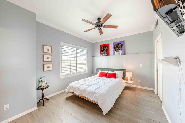 bedroom featuring light hardwood / wood-style flooring, ceiling fan, and crown molding