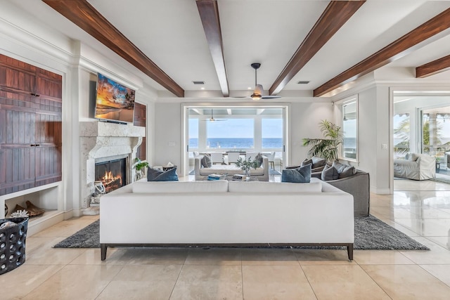 living room featuring beam ceiling, ceiling fan, a high end fireplace, and light tile patterned floors