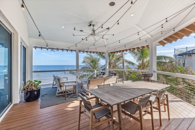 deck with ceiling fan and a water view