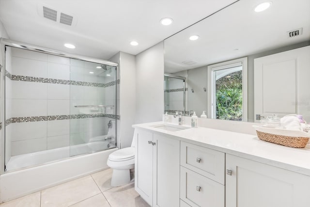 full bathroom with tile patterned floors, vanity, toilet, and shower / bath combination with glass door